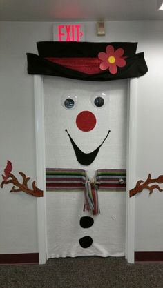 a door decorated to look like a snowman with a top hat and scarf on