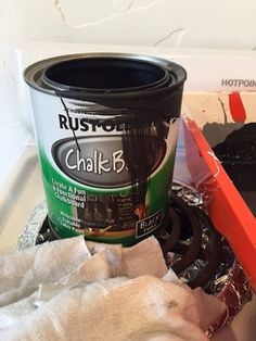 a can of paint sitting on top of a stove next to a pair of gloves