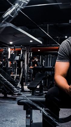 a man squatting on a bench in a gym