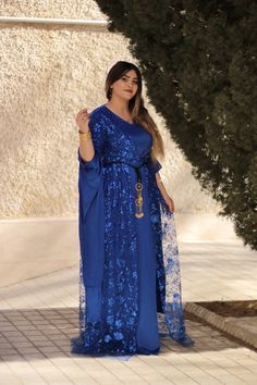 This beautiful royal blue Kurdish dress is designed to capture attention with its shimmering sequins and flowing silhouette, perfect for special occasions like weddings, cultural events, or formal gatherings. The traditional design is enriched with modern touches, offering a blend of elegance and cultural pride. The lightweight chiffon fabric allows for comfort, while the intricate hand-sewn sequins create a dazzling effect that is sure to stand out. The gown's long, draped sleeves enhance its g Kurdish Dress, Draped Sleeves, Cultural Festival, Drape Sleeves, Cultural Celebration, Chiffon Material, Cultural Events, Chiffon Fabric, Dress Clothes For Women