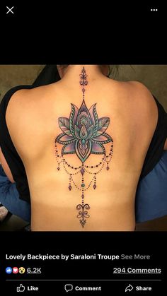 the back of a woman's body with an intricate tattoo design on her lower back