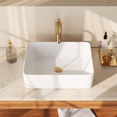 a white square sink sitting on top of a wooden counter next to a mirror and soap dispenser