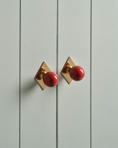 two red knobs on the side of a white door