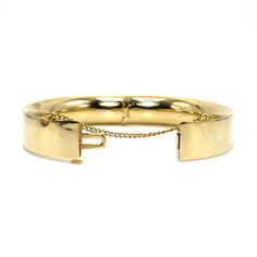 B.A. Ballou was founded in 1868 and continues to produce jewelry today. It is one of the oldest extant manufacturers of American jewelry. This lovely bangle is made of 14 karat yellow gold (the clasp is stamped "14K B.A.B.") and features a safety chain, which ensures the bracelet remains on the wearer should its clasp fail. This clasp is tight as new and the bracelet comes pre-engraved with a trigram that reads "MSM." Metal: 14K Yellow Gold Inside Diameter: 2.5 in. (average size) Vintage Yellow Gold Bangle Stamped 14k, Classic Gold Hinged Cuff Bracelet, Classic Gold Hinged Bangle, 14k Yellow Gold Cuff Bracelet For Formal Occasions, Heirloom 14k Gold Round Bracelet, Antique Oval Bangle For Formal Occasions, Antique Yellow Gold Cuff Bangle Bracelet, Classic Gold Hinged Bracelet, Classic Hinged Yellow Gold Jewelry