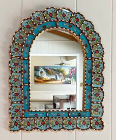 an ornate blue mirror hanging on the wall