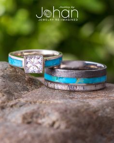 two wedding rings sitting on top of a rock with turquoise and white stone inlays