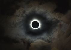 the solar eclipse is seen through clouds in this artistic photo