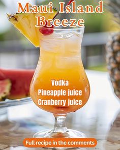 a pineapple juice is garnished with a slice of watermelon in the background