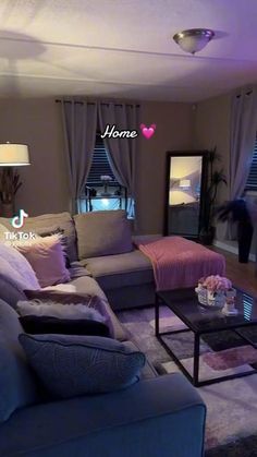 a living room filled with lots of furniture next to a large window covered in purple curtains