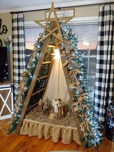 a nativity scene in the corner of a living room with christmas trees and plaid curtains