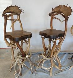 two chairs made out of antlers sitting next to each other