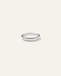 a white gold ring with five diamonds on the outside, set in 18k white gold