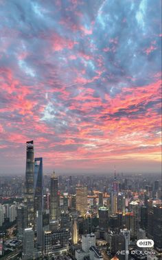 the city skyline is lit up at dusk with pink and blue clouds in the sky