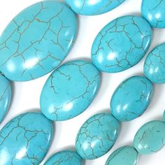 several turquoise stones are arranged on a white surface