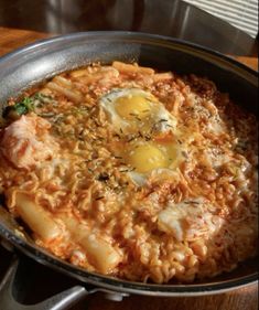 an iron skillet filled with pasta and eggs