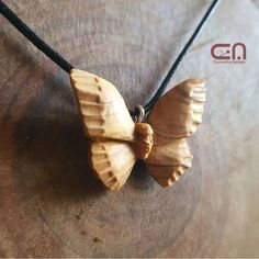 a wooden butterfly necklace on a black cord