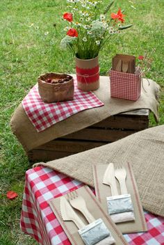 a picnic table set up with utensils and napkins