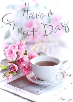 there is a cup of coffee and some pink flowers on the table with words have a great day