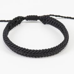 a black rope bracelet on a white background