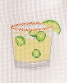 a cross - stitch picture of a drink with limes and an orange garnish