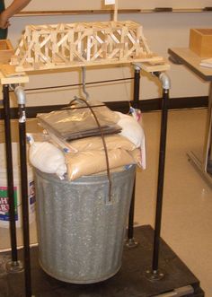 a person standing next to a trash can with bags on it and another bag in the background