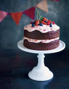 a chocolate cake with frosting and berries on top