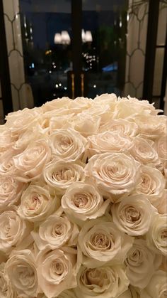 a large bouquet of white roses sitting on top of a table