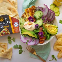 a bowl filled with salad next to tortilla chips and a bag of quesadilla