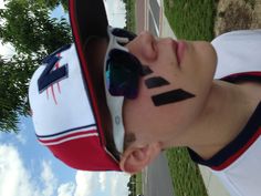 a young man with his face painted in the shape of a football team's flag