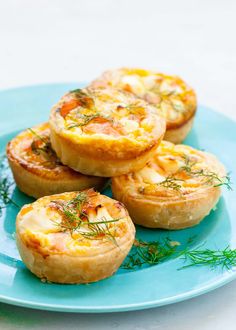 small quiches on a blue plate topped with fresh herbs