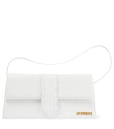 The Le Bambino Long shoulder bag is one of the smartest additions to Jacquemus' family of pint-sized bags. This compact leather design in white has an adjustable strap that can also be styled cross-body, and features golden logo lettering. | Jacquemus Le Bambino Long leather shoulder bag Jacquemus Le Bambino Long, Long Shoulder Bag, Jacquemus Bags, Jacquemus Bag, Best Online Stores, Golden Logo, Small Accessories, Leather Design, White Material