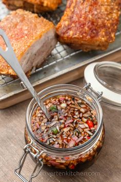 a jar filled with food sitting on top of a table next to some meats