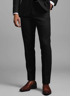 Make a move towards greater freedom, comfort, and versatility in our Napolean Black Wool Tuxedo Suit. Crafted from a luxurious wool blend, this suit exudes comfort, style, and sophistication. Its satin lapel and covered buttons add a refined touch, while the smooth texture offers a modern twist on classic tailoring. Perfect for weddings, black-tie events, or gala evenings, this tuxedo enhances your swagger, ensuring you stand out with effortless grace on any special night.   Featuring a satin la Fitted Tuxedo With Structured Boning For Workwear, Custom Fit Tuxedo For Work, Fitted Tuxedo With Pressed Crease For Work, Black Dress Pants With Concealed Placket For Tailoring, Fitted Wool Tuxedo Suit, Formal Wool Dress Pants With Pressed Crease, Formal Wool Fitted Dress Pants, Formal Black Dress Pants In Suiting Fabric, Black Luxury Dress Pants For Formal Occasions