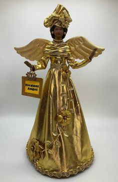 a gold angel figurine holding a sign