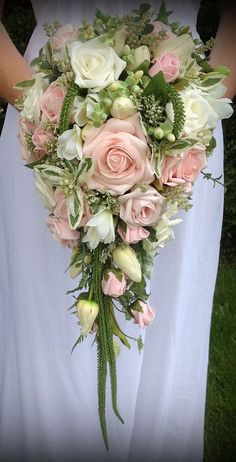 a bride holding a bouquet of pink and white flowers