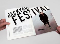 a person holding up a magazine with an image of a man in black on it