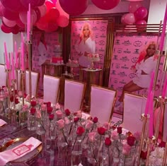 a table set up with pink roses and candles for a barbie themed birthday party,