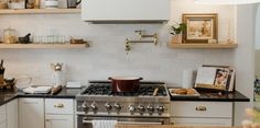 a stove top oven sitting inside of a kitchen next to a counter with food on it