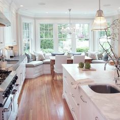 a kitchen with white cabinets and counter tops next to a stove top oven in a living room