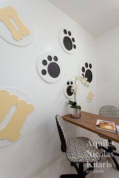 an office with white walls and black and gold animal prints on the wall above a desk