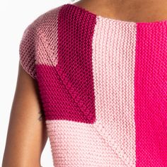 a woman wearing a pink and white knitted top with two different colored squares on it