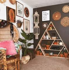 a living room filled with furniture and pictures on the wall next to a shelf full of plants