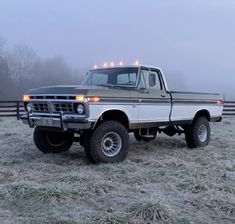 an old pick up truck parked in a field