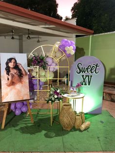 a table with pictures and balloons on it at a sweet sixteen event in the evening