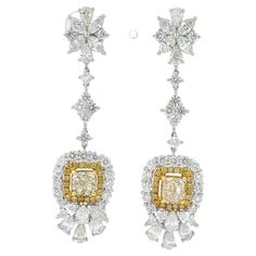 Introducing our stunning dangle earrings, the perfect addition to your jewelry collection. These exquisite earrings feature a total of 2.42 carats of brilliant yellow diamonds, which catch the light beautifully and add a pop of color to any outfit. The earrings also feature 1.79 carats of marquise diamonds, 1.74 carats of pear diamonds, and 2.51 carats of round diamonds, all expertly set in 18 karat white gold. The design of these earrings is truly eye-catching, with a total length of 52mm that will elegantly dangle from your ears. The intricate placement of the diamonds creates a dazzling effect that will leave you feeling glamorous and sophisticated. Crafted with the utmost care and attention to detail, these earrings are sure to become a treasured piece in your collection. Perfect for a Luxury Gold Danglers With Intricate Design, Luxury 22k Yellow Gold Danglers, Luxury Diamond Dangle Earrings With Halo Design, Luxury Dangle Diamond Earrings With Halo Design, Gia Certified Diamond Drop Earrings, Luxury Halo Design Dangle Earrings, Luxury Dangle Earrings With Halo Design, Luxury Gia Certified Dangle Diamond Earrings, Luxury Yellow Dangle Earrings