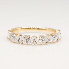 a yellow gold wedding band with five pear shaped diamonds