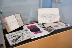 an open book sitting on top of a wooden table next to papers and other items