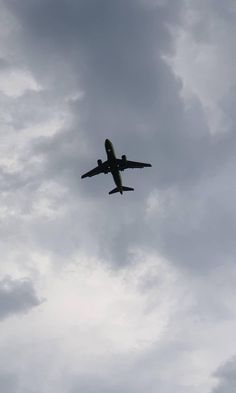 an airplane is flying through the cloudy sky