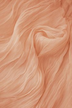 the texture of an orange fabric is very soft and blurry in this image, it looks like waves