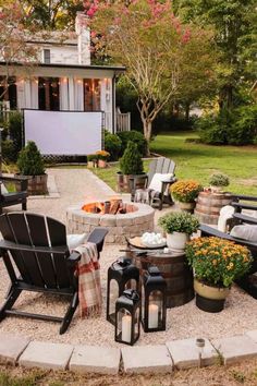 an outdoor patio with chairs, fire pit and potted plants